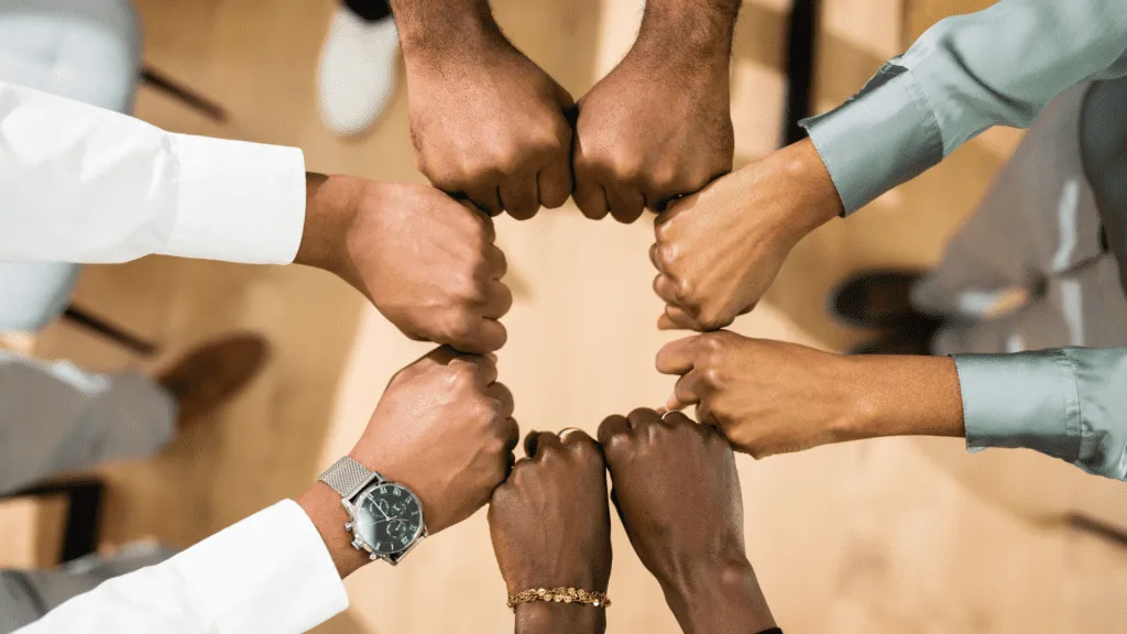 Four pairs of hands with fists clenched in a circle for 5 minute games